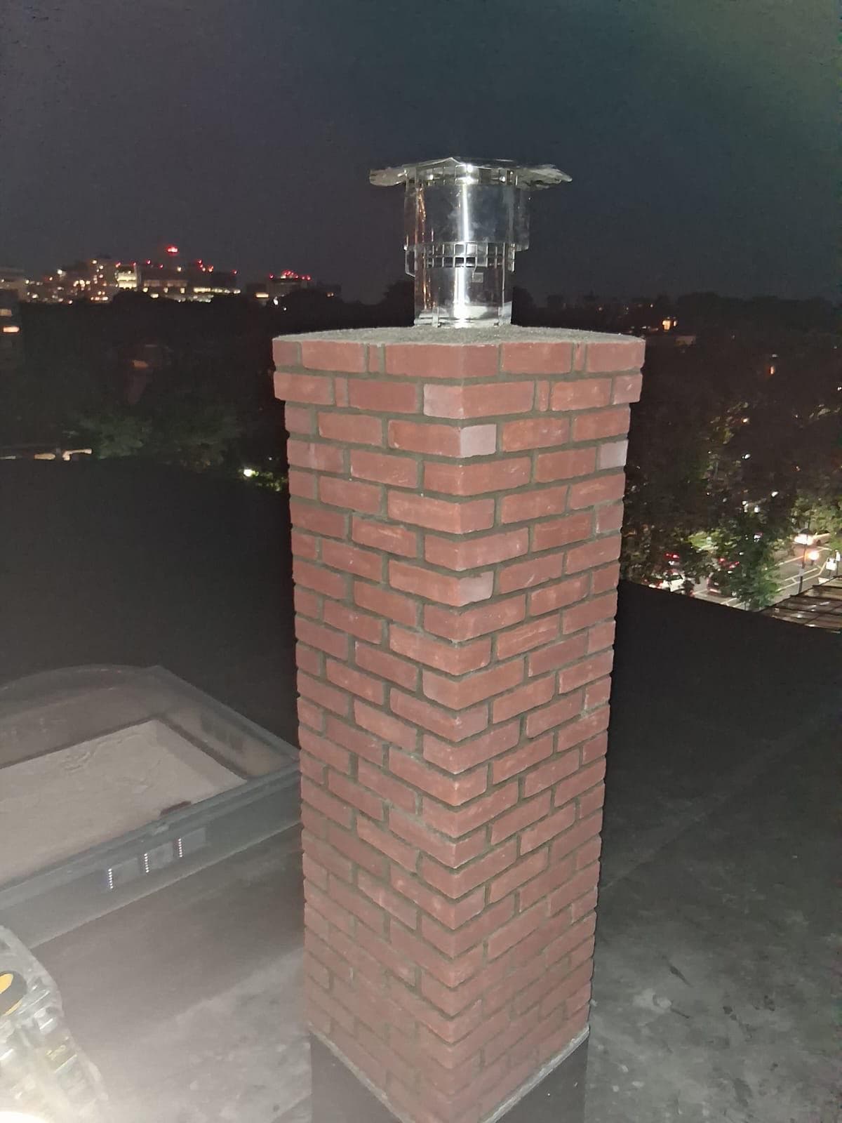 Newly rebuilt red brick chimney with a stainless cap in Massachusetts