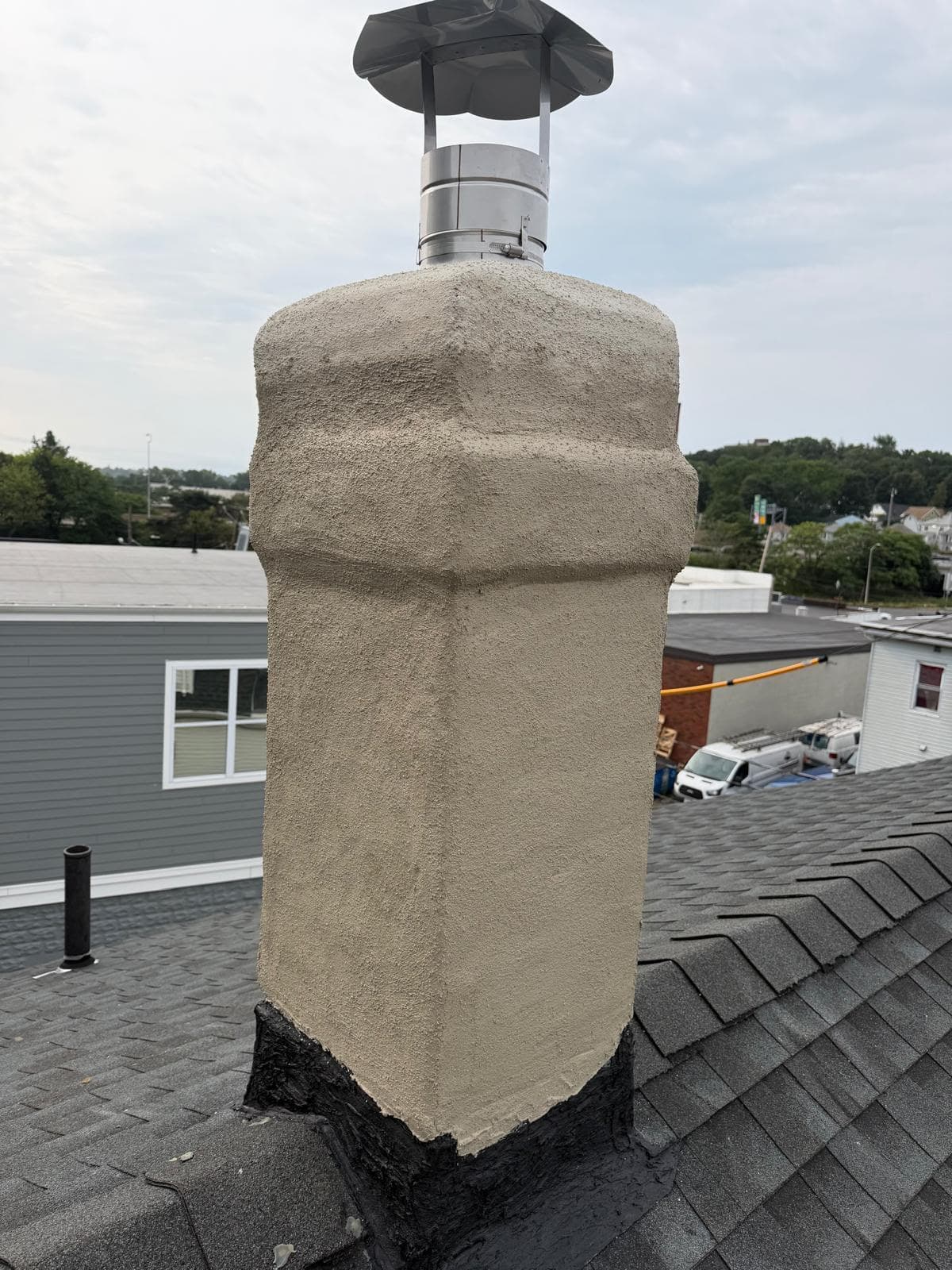 Chimney re-parged with a cement coat and topped with a stainless rain cap in Massachusetts