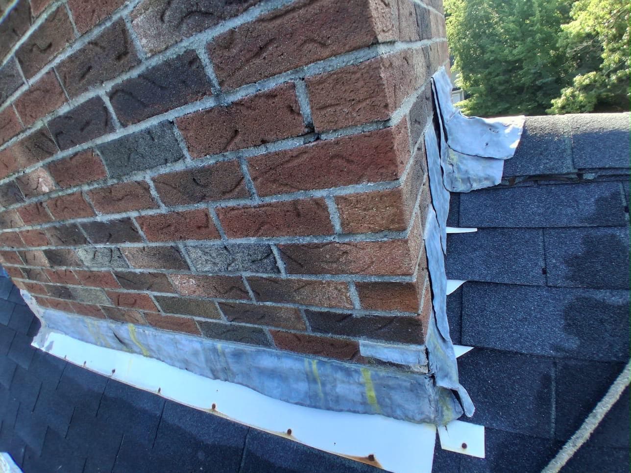 Deteriorated chimney flashing lifting away from the roof, letting water in