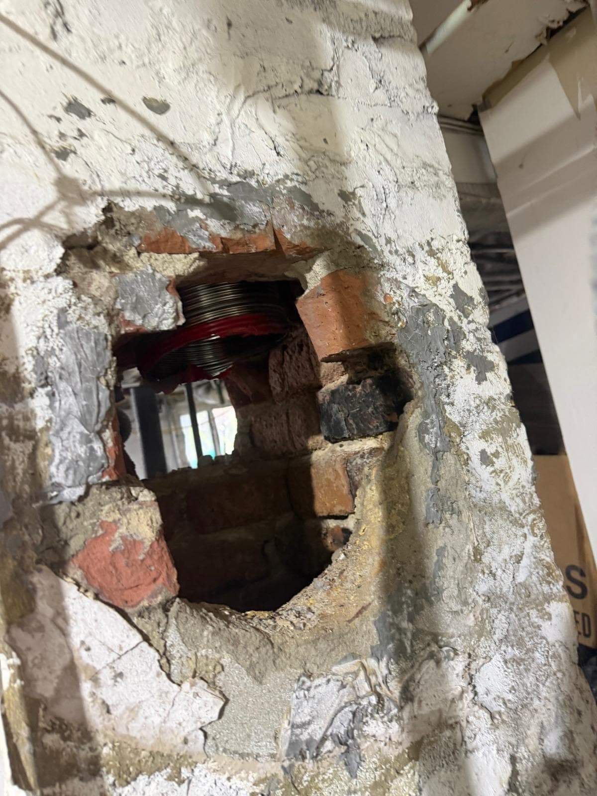 Chimney breast opened to route a new stainless steel liner through the masonry